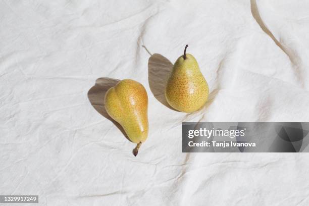 pears on white tablecloth. summer fruits. flat lay, top view. minimal style. - linnen stockfoto's en -beelden