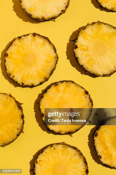 creative summer pattern made of pineapple slices on bright yellow background. minimal fruits concept. flat lay, top view. - パイナップル ストックフォトと画像