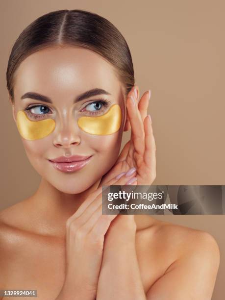 woman with eye patches under her eyes - medical eye patch stockfoto's en -beelden