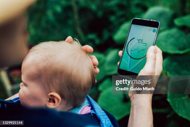 woman looking at mobile phone with analysing app for growh conditions. - mobile screen stock-fotos und bilder
