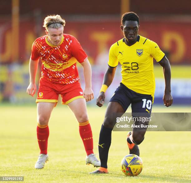 Josh Anifowose of Oxford United runs with the ball under pressure from a Banbury United trialist during the Pre-Season Friendly match between Banbury...