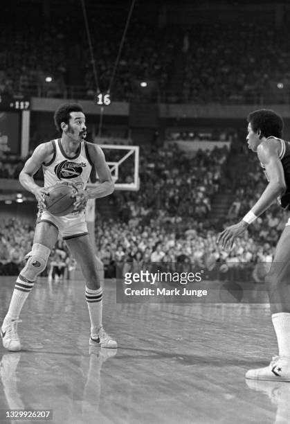 Denver Nuggets forward Willie Wise prepares to pass the ball to a teammate as San Antonio Spurs forward Larry Kenon takes a defensive stance during...