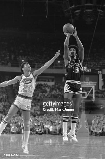 San Antonio Spurs guard Mike Gale takes a jump shot in the key while Denver Nuggets guard Mack Calvin tries to block it during an NBA basketball game...