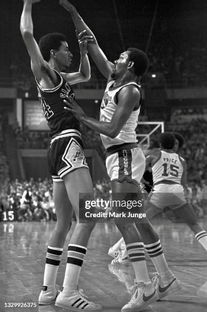 San Antonio Spurs forward George Gervin holds the ball away from defending Denver Nuggets guard Ted McClain during an NBA basketball game at...