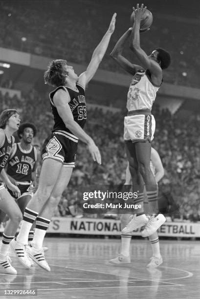 Denver Nuggets forward David Thompson takes a jump shot over the outstretched arm of San Antonio Spurs forward Mark Olberding during an NBA...