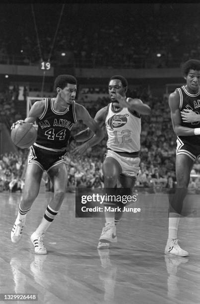 San Antonio Spurs forward George Gervin dribbles the ball past Denver Nuggets guard Ted McClain during an NBA basketball game at McNichols Arena on...