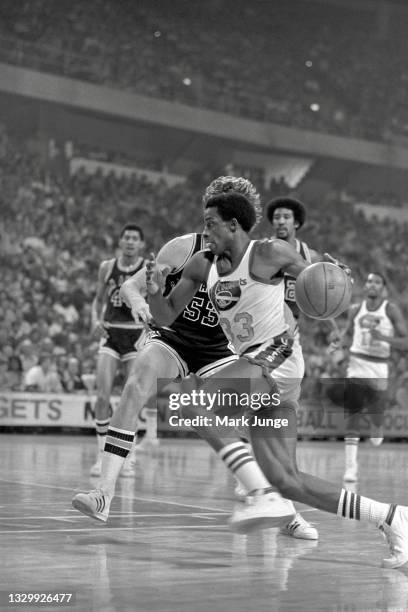 Denver Nuggets forward David Thompson drives past San Antonio Spurs forward Mark Olberding during an NBA basketball game at McNichols Arena on March...