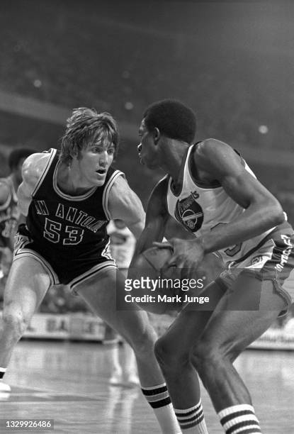 Denver Nuggets forward David Thompson holds the ball away from San Antonio Spurs forward Mark Olberding during an NBA basketball game at McNichols...