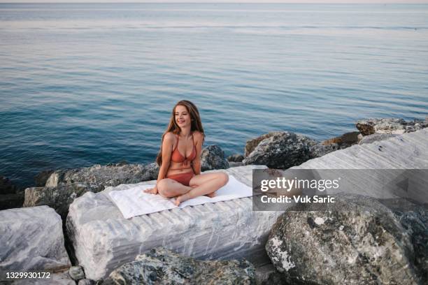 sitting by the sea on the rocks - harmony day stock pictures, royalty-free photos & images