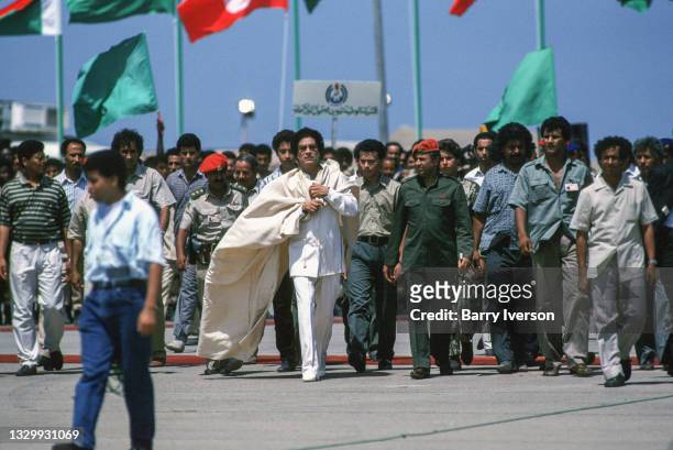 Libyan President Muammar Gaddafi and his entourage arrives walk across the tarmac at Mitiga Airport outside Tripoli, Libya, 1989.