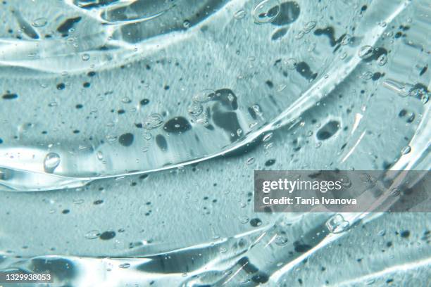 texture of gel cream. liquid hyaluronic acid gel on blue background. - serum stock pictures, royalty-free photos & images