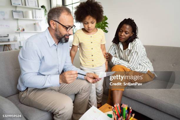 mature adult male psychologist testing by the drawing a young girl - child psychologist stock pictures, royalty-free photos & images