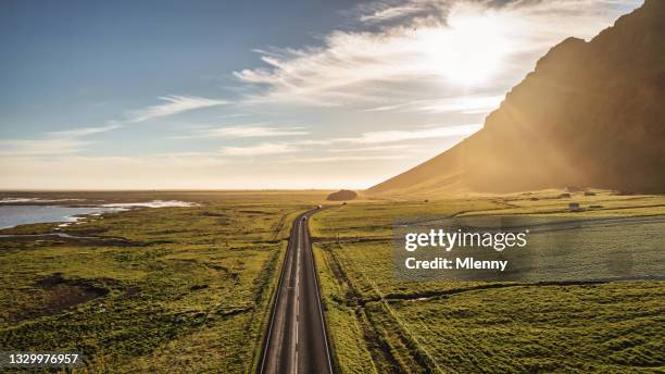 iceland country road into the sun panorama empty route 1 summer sunset - ijsland panorama stockfoto's en -beelden