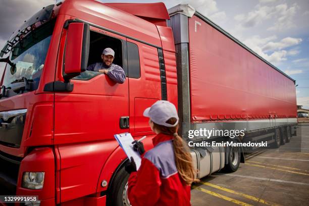 truck driver and delivery person going through the shipping manifest - trucking industry stock pictures, royalty-free photos & images