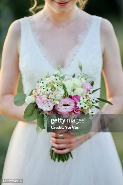 bride holding her bouquet with flowers - green dress stock pictures, royalty-free photos & images