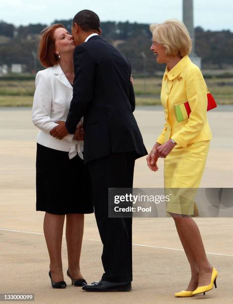 President Barack Obama kisses Australian Prime Minister Julia Gillard as Australian Governor General Quentin Bryce laughs during his arrival at...