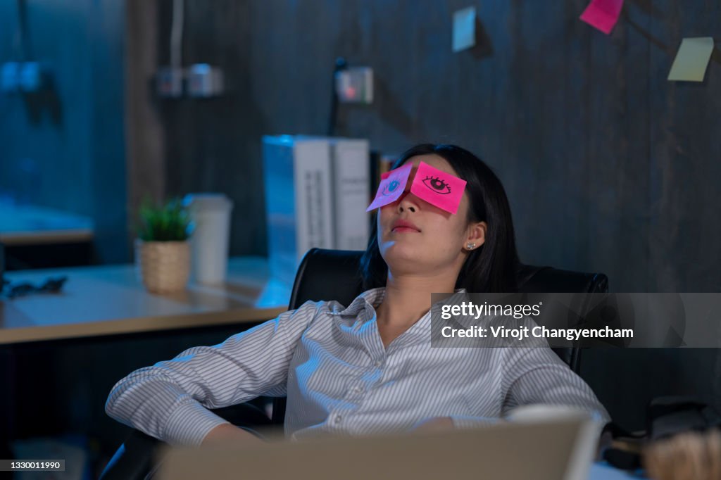 Young female work hard and sleep while working late