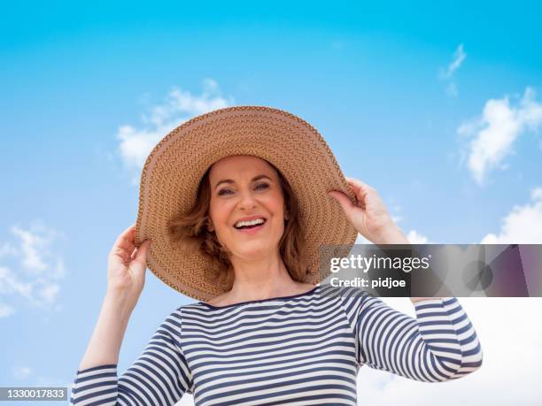 mature woman with beach hat - sun hat stock pictures, royalty-free photos & images