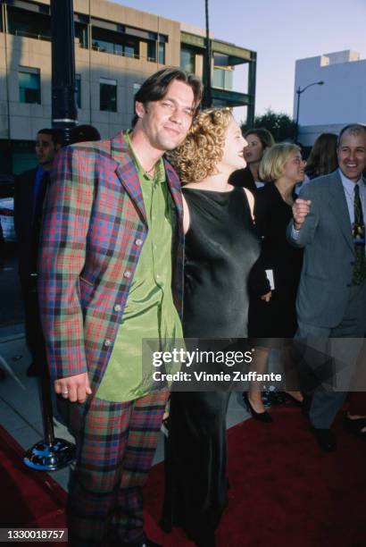 British actor Dougray Scott, wearing a tartan suit with a green shirt, and American actress Drew Barrymore, wearing a black sleeveless evening gown,...
