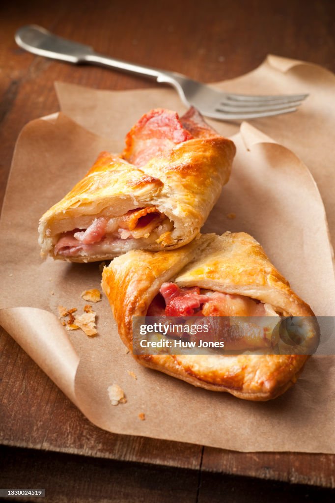 Bacon and cheese puff pastry turnover on parchment paper