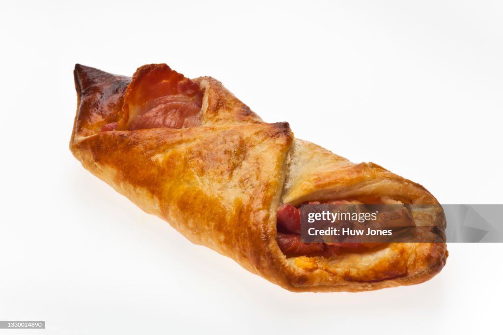 Bacon and cheese puff pastry turnover on a white isolated background