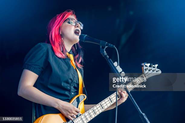 bajista y signer femenina tocando en vivo - concierto rock fotografías e imágenes de stock