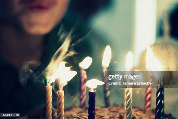 boy blowing candles - pusten stock-fotos und bilder