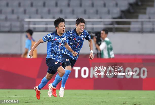 Takefusa Kubo of Team Japan celebrates with teammate Hiroki Sakai after scoring their side's first goal during the Men's First Round Group A match...