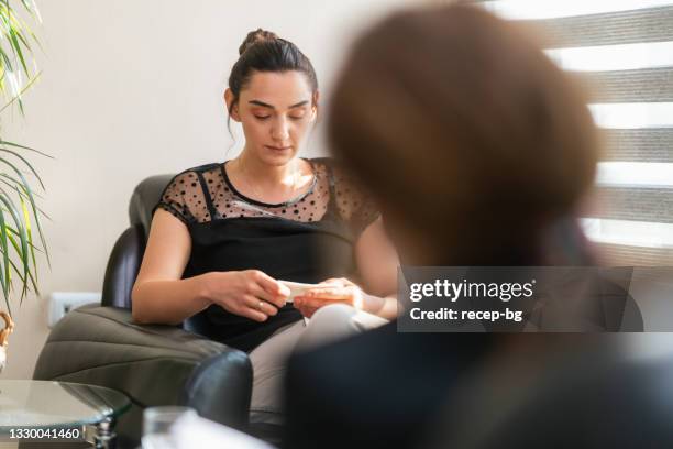 young woman talking sadly with mental health care professional - emotional support 個照片及圖片檔