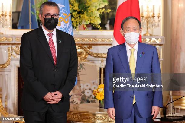 World Health Organization Director-General Tedros Adhanom and Japanese Prime Minister Yoshihide Suga pose for photographs before their meeting ahead...