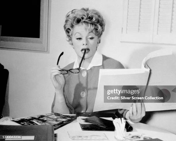 Lucille Ball , US comedian and actress, holding eyeglasses and script, circa 1960.