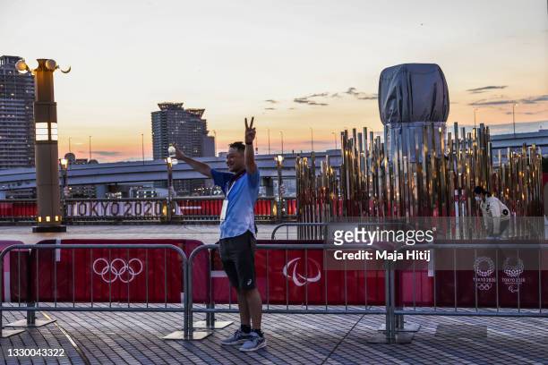 Volunteer poses for a photo next to the second cauldron ahead of the Tokyo 2020 Olympic Games on July 22, 2021 in Tokyo, Japan.