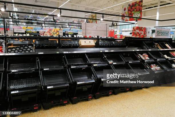 Empty shelves where tomatoes were being sold at an ASDA store on July 21, 2021 in Cardiff, United Kingdom. Supermarkets across the UK are emptying of...
