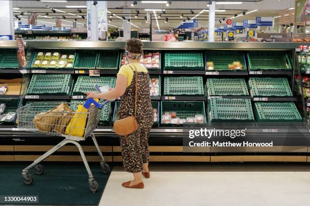 Shelves with low stock at a Tesco store on July 21, 2021 in Cardiff, United Kingdom. Supermarkets across the UK are emptying of fresh produce and...