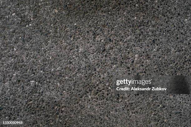 smooth dark gray texture of asphalt pavement made of small stones and concrete. sidewalk or roadway. textured grainy background. - porous stock pictures, royalty-free photos & images