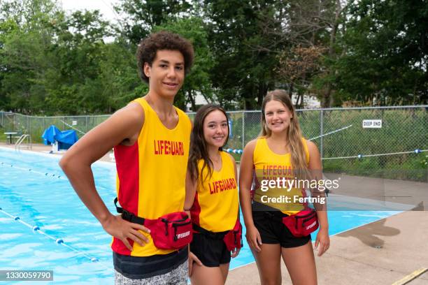 glückliche teenager-rettungsschwimmer - rettungsschwimmer stock-fotos und bilder