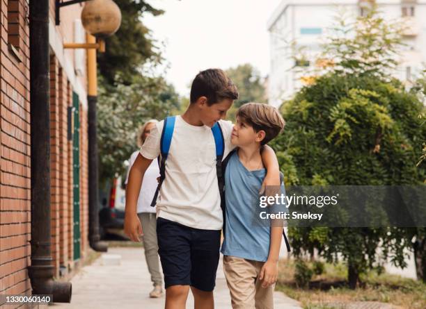 schoolboys going to class, hugging and smiling. - brothers imagens e fotografias de stock