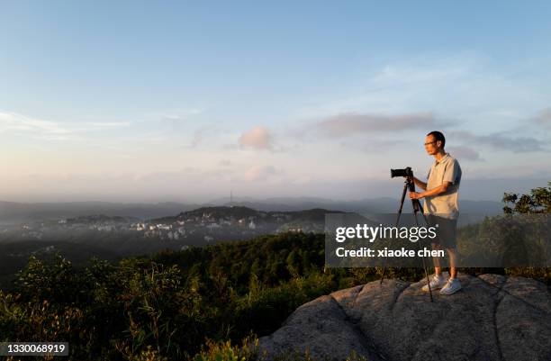 artista masculino asiático tomando fotos en la cima de la montaña - fuzhou fotografías e imágenes de stock