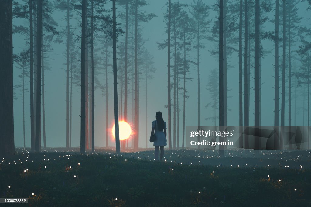 Woman with mystery glowing orb in the forest at night
