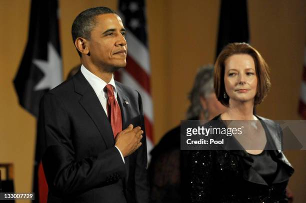 Australian Prime Minister Julia Gillard watches US President Barack Obama during the playing of the national anthems before a parliamentary dinner on...