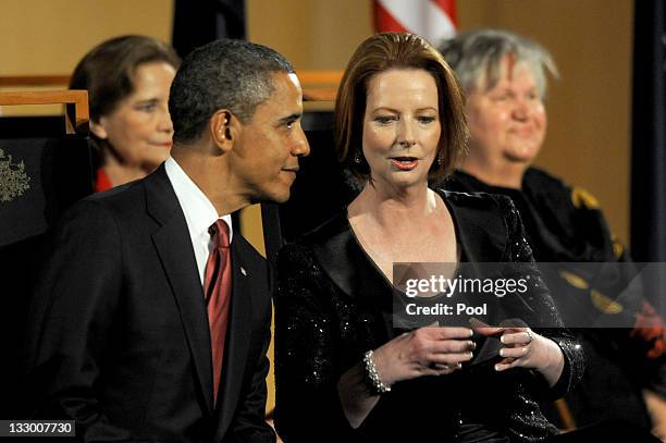 Australian Prime Minister Julia Gillard speaks to United States President Barack Obama before a parliamentary dinner on the first day of his 2-day...