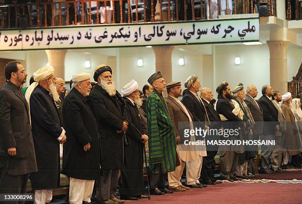 President Hamid Karzai listens to national anthem during a four-day long loya jirga, a meeting of over 2,000 Afghan tribal elders and leaders in...