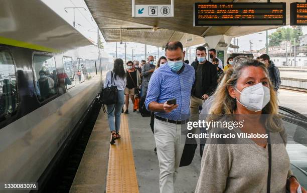 Mask-clad travelers rush to board an Alfa Pendular train to Lisbon in Campanha station during the COVID-19 Coronavirus pandemic on July 22, 2021 in...