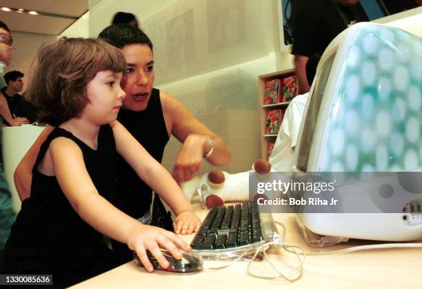 Jill Kobe from San Francisco watches her three-year-old daughter Madeline try-out a new iMac computer during the grand opening of The Apple Store,...