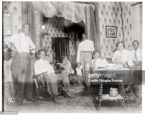 Portrait of an unidentified group of men and women, along with a dog, in a living room, Lincoln, Nebraska, early 20th century.