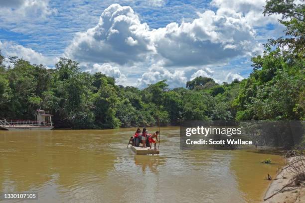 Members of the Awá tribe cross the Pindaré River with their ATV on a raft at the entrance to Caru Indigenous Land, Maranhão, Brazil, 2017. Awá...