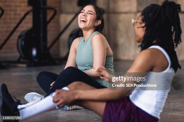 female friends laugh together during break from exercising at gym - adult braces stock pictures, royalty-free photos & images