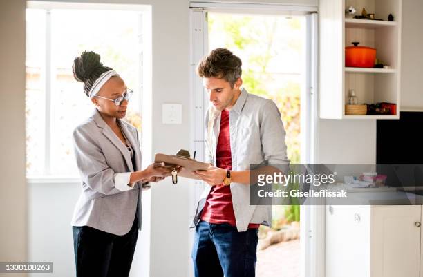 young man signing new home contract - reading contract stock pictures, royalty-free photos & images