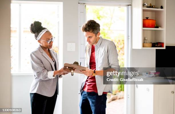 young man signing new home contract - contrato de arrendamento imagens e fotografias de stock