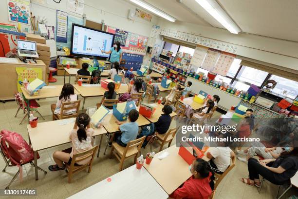 Melissa Moy, a teacher at Yung Wing School P.S. 124, goes over a lesson with in-person summer program students on a monitor on July 22, 2021 in New...